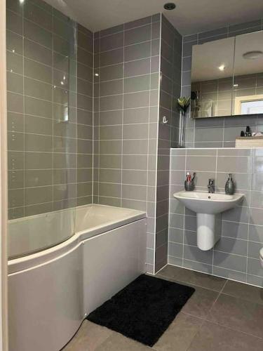 a bathroom with a bath tub and a sink at Lovely One Bedroom Apartment, with on-site Parking in Thamesmead