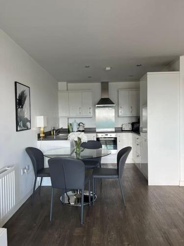 a kitchen with a table and chairs in a room at Lovely One Bedroom Apartment, with on-site Parking in Thamesmead