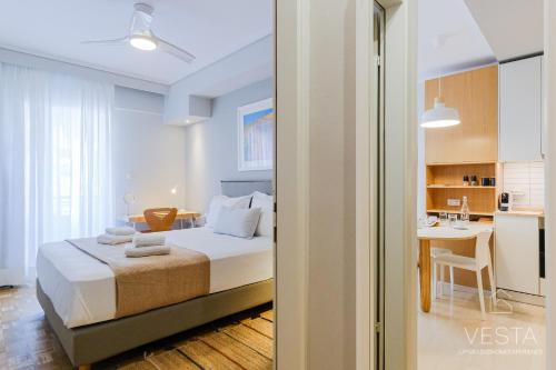 Cet appartement comprend une chambre avec un lit et une cuisine avec une table. dans l'établissement The Modern World Apartment, Vesta Philoxenia, à Thessalonique