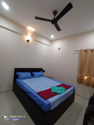 una camera con letto e ventilatore a soffitto di Swami Nivas a Malwan