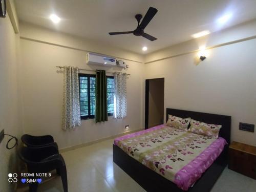 una camera con letto e ventilatore a soffitto di Swami Nivas a Malwan
