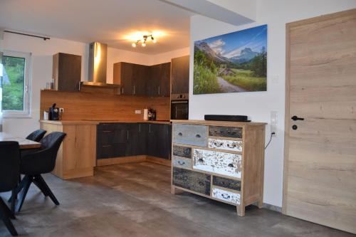 a kitchen with a dresser with a painting on the wall at Happy Nest in Göstling an der Ybbs