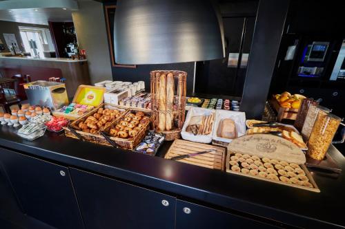 een buffet met veel verschillende soorten eten op een aanrecht bij Campanile Evry Ouest - Corbeil Essonnes in Corbeil-Essonnes