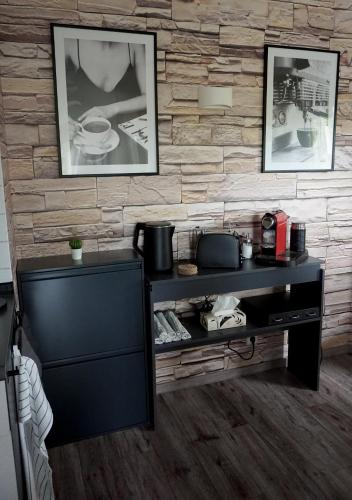 a black shelf in a room with a brick wall at Schöne Wohnung mit Terrasse & Blick ins Grüne in Dormettingen