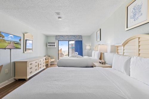 a large bedroom with two beds and a window at SeaMist Driftwood Vacation Studio with Balcony in Myrtle Beach