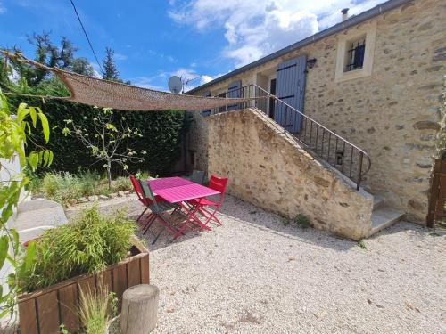 une terrasse avec une table et des chaises devant un bâtiment dans l'établissement Gites Lydil, à Nyons