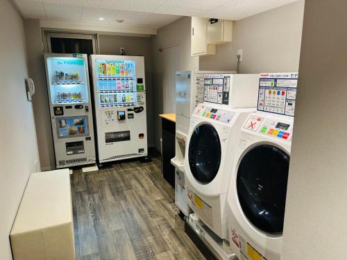 a laundry room with two washes and two refrigerators at Ginza International Hotel in Tokyo