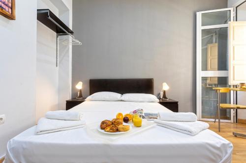 マラガにあるLivemalaga Letrán Apartmentの白いベッド(一皿の上に一皿の食べ物が入ったもの)