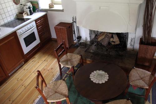 a kitchen with a table and chairs and a fireplace at The Stonehouse in Stemnitsa