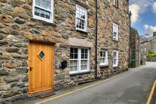 a wooden door on the side of a stone building at Finest Retreats - Hope House - Ty Gobaith in Dolgellau