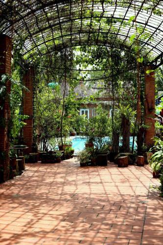 a brick courtyard with a pool in a building at Bầu Bí Mini Farmstay Mekong - Tiền Giang in My Tho