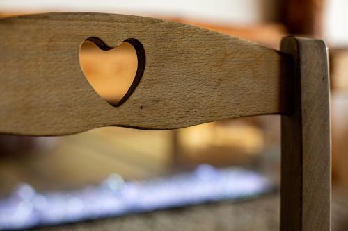 a wooden bench with a heart carved into it at Chalet Cormignano in Vezza dʼOglio
