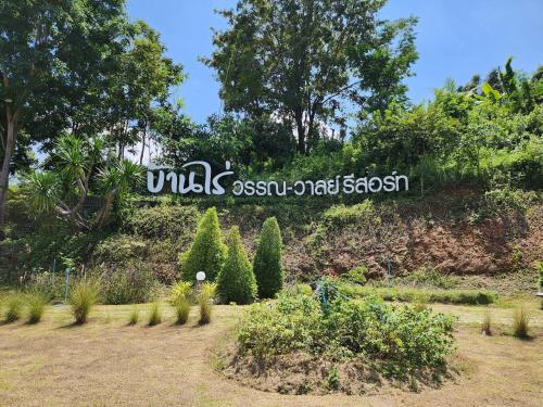 a garden with trees and plants in a field at บ้านไร่ วรรณ วาลย์ รีสอร์ท in Tha Kradan