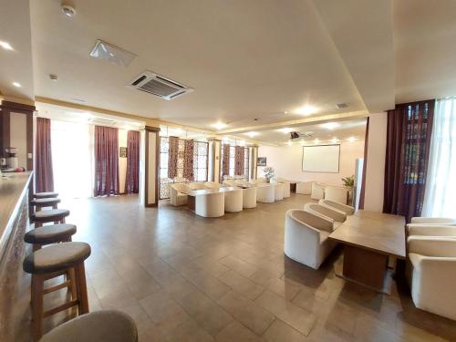 uma grande sala de espera com cadeiras brancas e uma mesa em Sheki Olimp Villa em Sheki