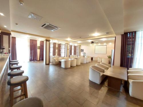 a large waiting room with white chairs and a table at Arena Hotel Sheki in Sheki