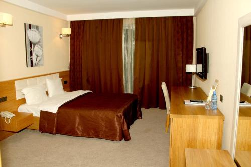 a hotel room with a bed and a desk at Arena Hotel Sheki in Sheki