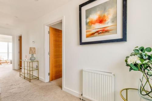 a living room with a vase of flowers on a wall at Cliff Top Heights-Beach front house near Brighton in Rottingdean