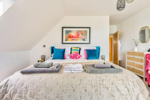 a bedroom with a large bed with blue pillows at Cliff Top Heights-Beach front house near Brighton in Rottingdean