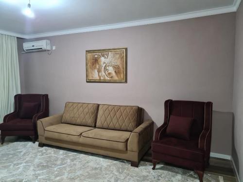 a living room with a couch and two chairs at Avtovokzal 3 Room apt in Qyzylorda