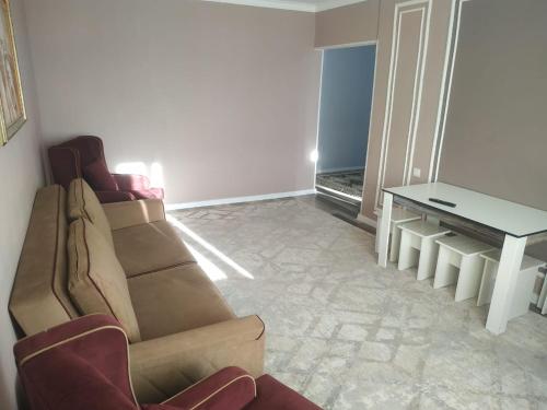 a living room with a couch and a table at Avtovokzal 3 Room apt in Qyzylorda