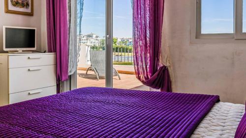 un letto viola in una camera da letto con finestra di Stunning Townhouse with wonderful views on La Torre Golf Resort 2 Bed 2 Bathroom LA228LT a Torre-Pacheco