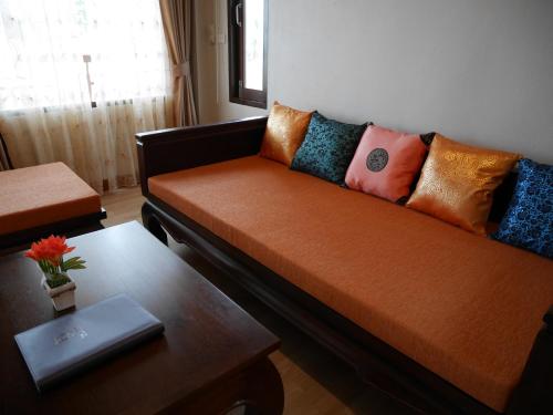 a couch with pillows on it in a living room at The Sunset Beach Resort - Koh Kho Khao in Ko Kho Khao