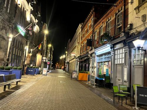 an empty street at night with benches and buildings at Top Floor in Lincoln