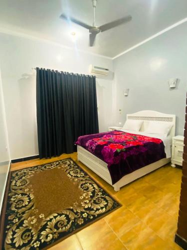 a bedroom with a bed and a rug on the floor at Temple House Luxor in Luxor