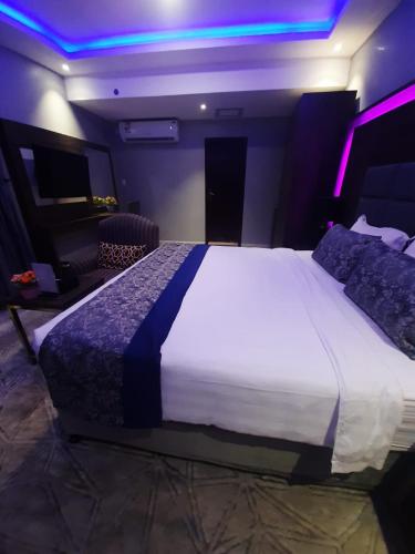 a bedroom with a large bed with purple lights at شقق سوات للشقق المخدومة 2 in Al Khobar