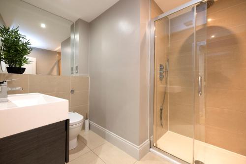 een badkamer met een douche, een toilet en een wastafel bij JOIVY Splendid 1-BR Flat near Edinburgh Castle in Edinburgh