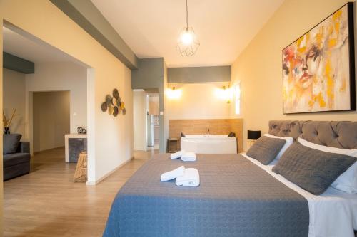 a bedroom with a large bed with towels on it at Belajo Central Apartment And Jacuzzi !! in Volos