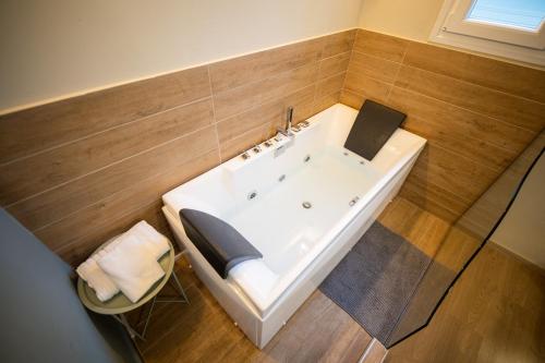 a bath tub in a bathroom with wooden walls at Belajo Central Apartment And Jacuzzi !! in Volos