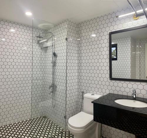 uma casa de banho com um WC, um lavatório e um espelho. em Khách sạn Robin Gia Nghĩa em Gia Nghĩa