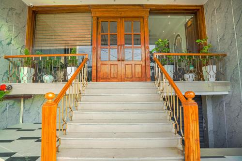 a set of stairs leading to a wooden door at Hotel Grand Cabbana By Levelup Hotels in Amritsar
