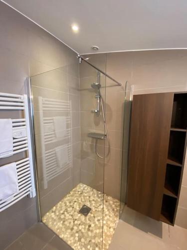une douche avec une porte vitrée dans une salle de bain dans l'établissement Jolie maison réthaise *** - Grand jardin privatif, à La Couarde-sur-Mer