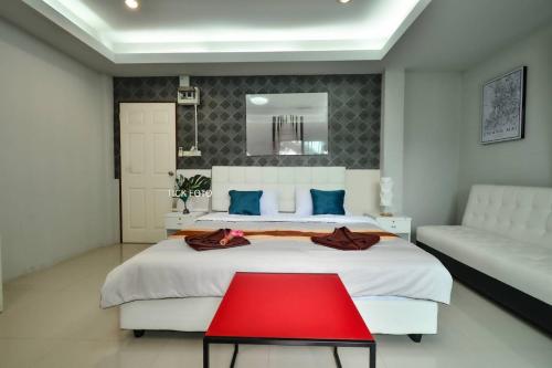 a bedroom with a large white bed and a red table at Sphat เอสพลัส Boutique Hotel chiang mai in Chiang Mai