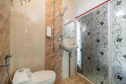 a bathroom with a toilet and a sink at RedDoorz Syariah near Minangkabau International Aiport in Duku