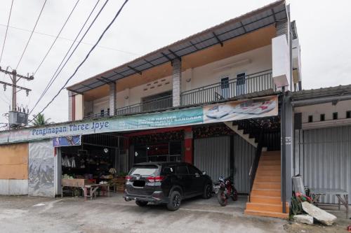 a car parked in front of a building at RedDoorz Syariah near Minangkabau International Aiport in Duku