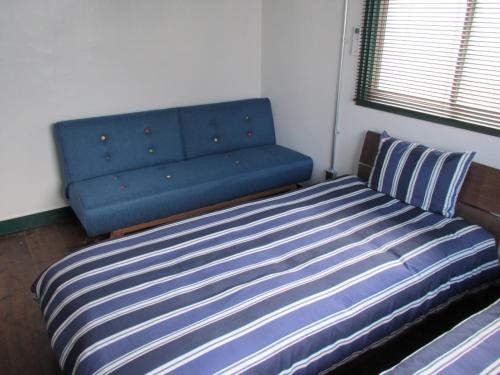 a blue couch in a room with a bed at Fukuoka - House / Vacation STAY 4617 in Fukuoka