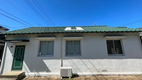 a white house with a green roof at Fukuoka - House / Vacation STAY 4617 in Fukuoka