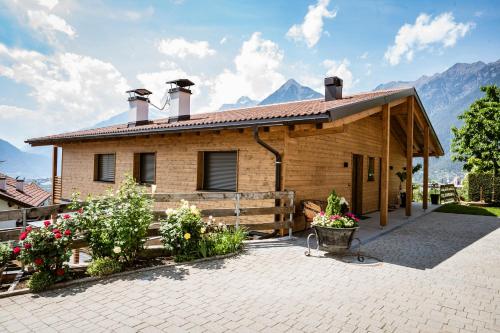 a small wooden house with mountains in the background at Hilburgerhof in Schenna