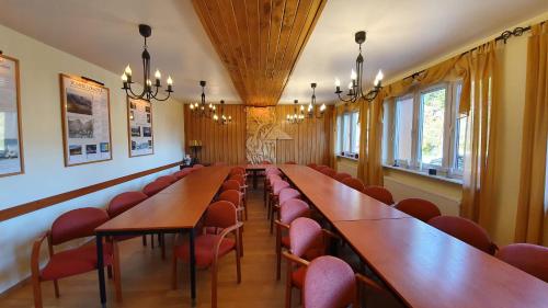 a conference room with wooden tables and red chairs at Pokoje Gościnne przy kościele Wang. in Karpacz