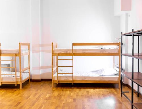 two bunk beds in a room with wooden floors at Alias Hostel in Pristina