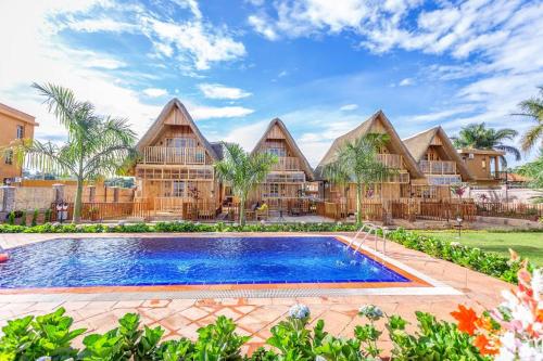 eine Villa mit einem Pool und einem Resort in der Unterkunft Pelican Lodge & Marina in Entebbe