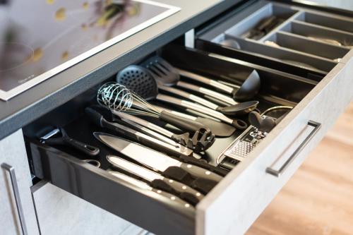 a drawer filled with cooking utensils in a kitchen at Hilburgerhof in Schenna