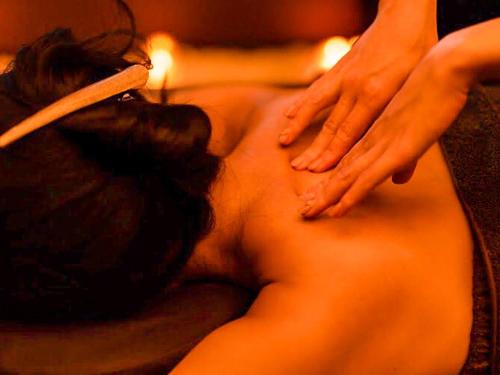 a woman getting a back massage in a towel at マングタックリゾート尾道 in Onomichi