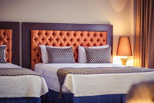 a bedroom with two beds and a large headboard at Hotel Intourist Palace Batumi in Batumi