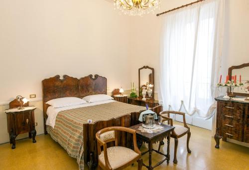 a bedroom with a bed and a table and chairs at Villa La Meridiana - Caroli Hotels in Leuca