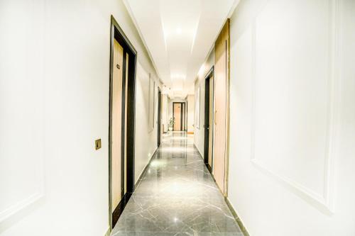 a hallway with white walls and a tile floor at Hotel Grand Cabbana By Levelup Hotels in Amritsar