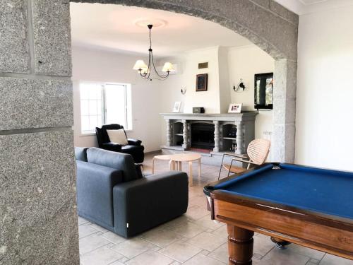 a living room with a pool table and a fireplace at Maison familiale de caractère avec piscine in Padronelo
